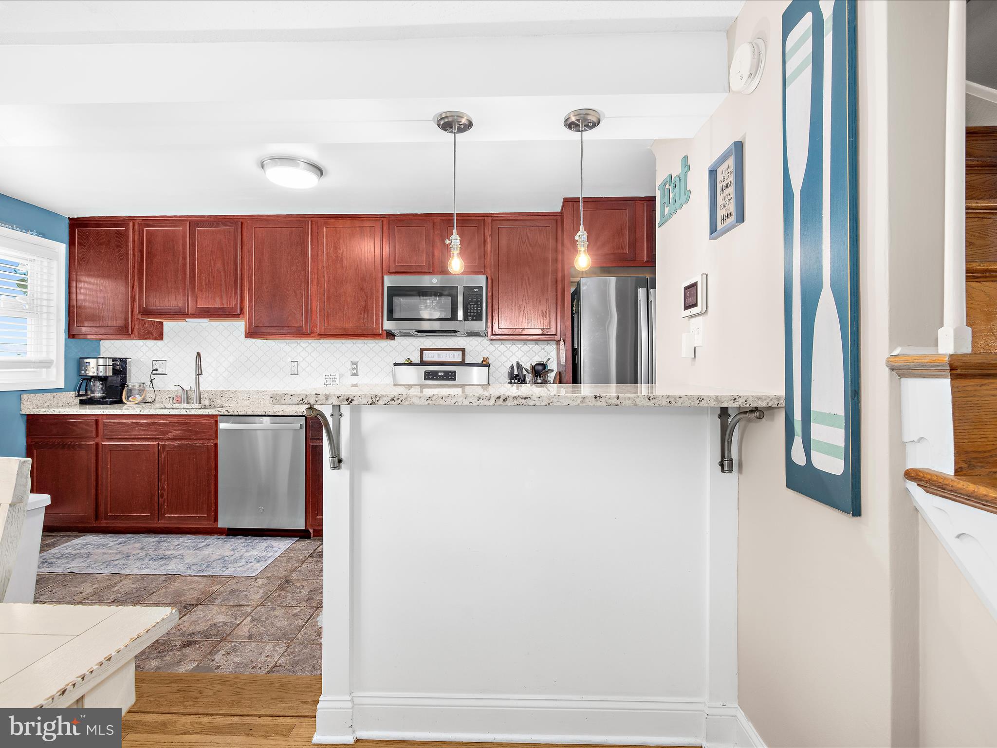 7851 Kentley Road Baltimore, MD 21222 - Photo 10 of 58 a kitchen with stainless steel appliances granite countertop a refrigerator a sink dishwasher a stove with wooden cabinets and floor