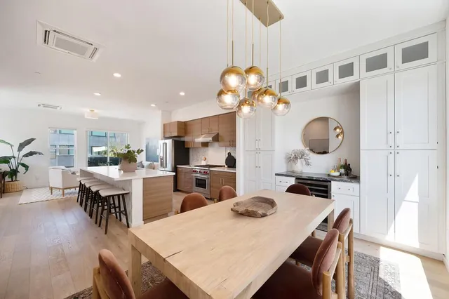 a kitchen with stainless steel appliances kitchen island granite countertop a sink a stove and a wooden floors