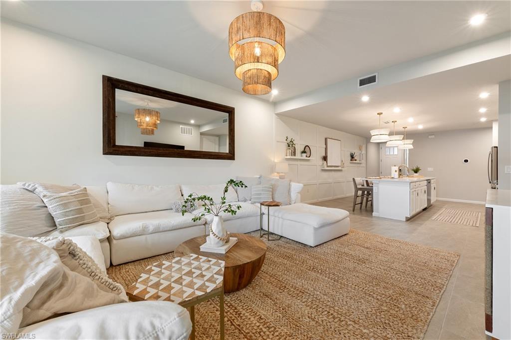 4638 Arboretum Circle, Unit 102 Naples, FL 34112 - Photo 14 of 20 a living room with furniture and a chandelier