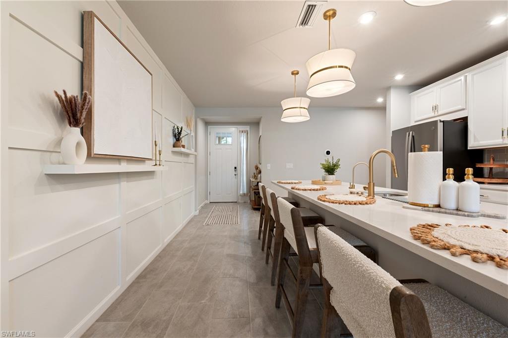 4638 Arboretum Circle, Unit 102 Naples, FL 34112 - Photo 15 of 20 a large kitchen with a table and chairs