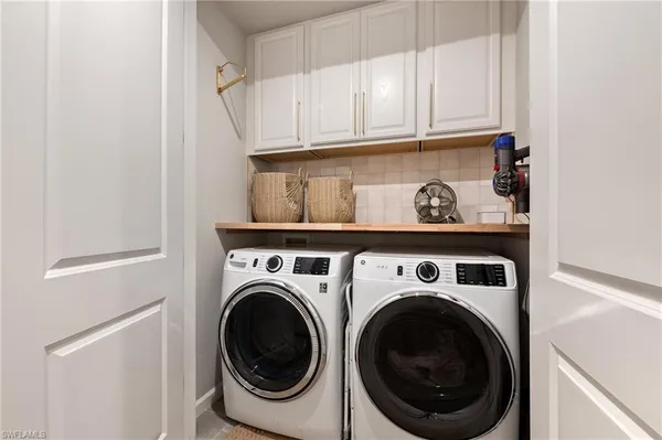 a kitchen with stainless steel appliances granite countertop a refrigerator a stove top oven a sink dishwasher and white cabinets with wooden floor