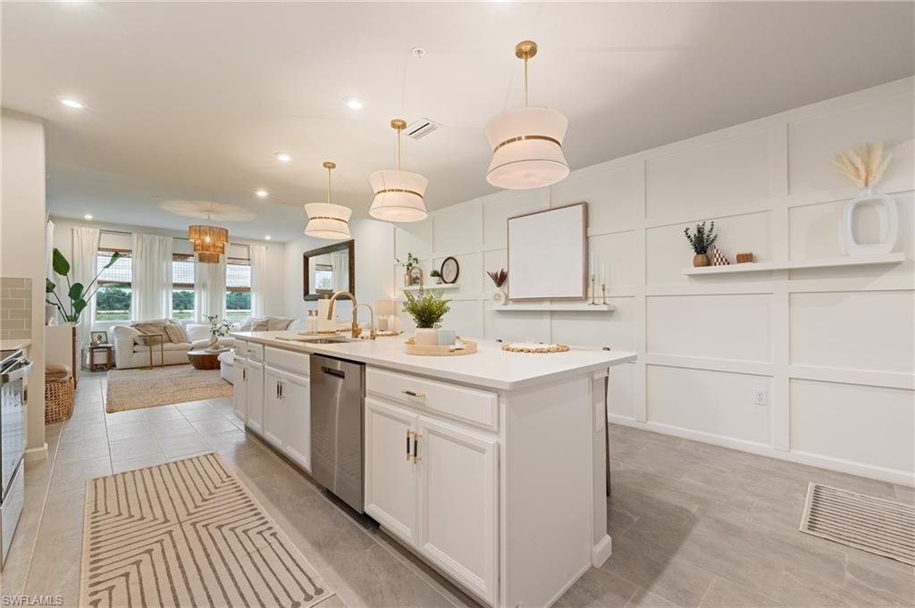 4638 Arboretum Circle, Unit 102 Naples, FL 34112 - Photo 19 of 20 a kitchen with kitchen island a sink appliances and cabinets