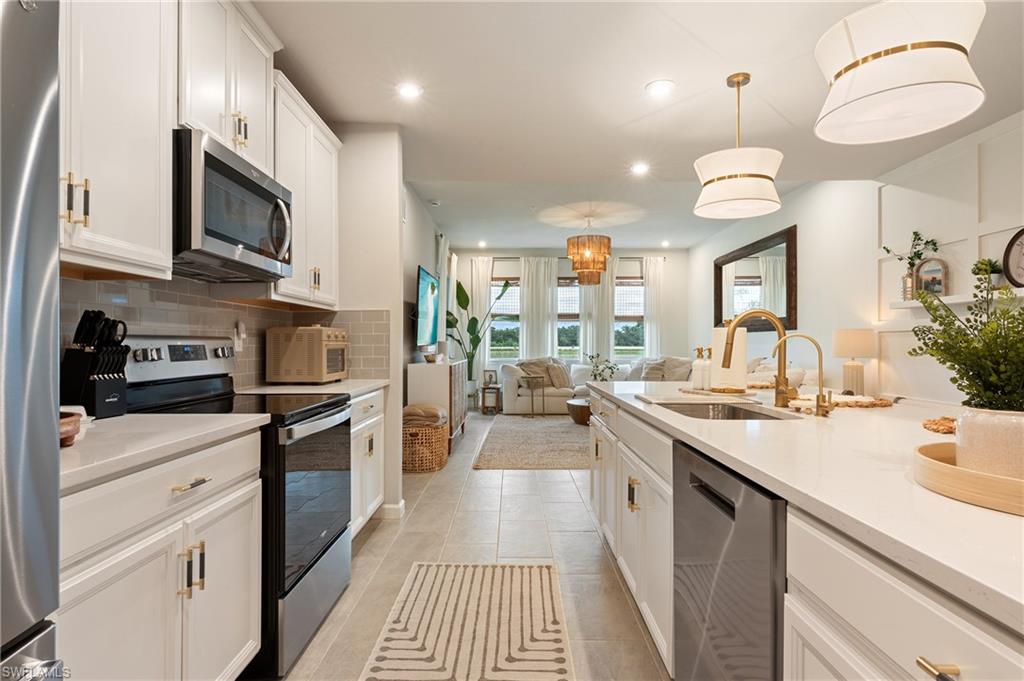 4638 Arboretum Circle, Unit 102 Naples, FL 34112 - Photo 20 of 20 a kitchen with stainless steel appliances a stove sink and cabinets