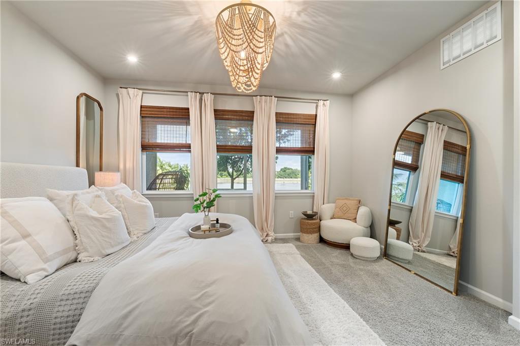 4638 Arboretum Circle, Unit 102 Naples, FL 34112 - Photo 5 of 20 a bedroom with a bed and a chandelier