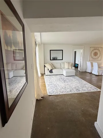 a bedroom with a large bed and wooden floor