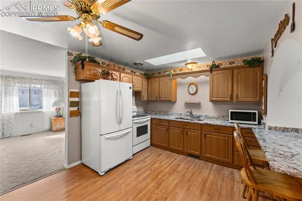 a kitchen with stainless steel appliances granite countertop a refrigerator a stove and a sink
