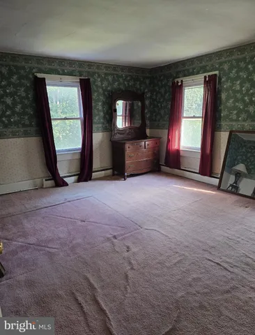 a view of an empty room with a fireplace and a window