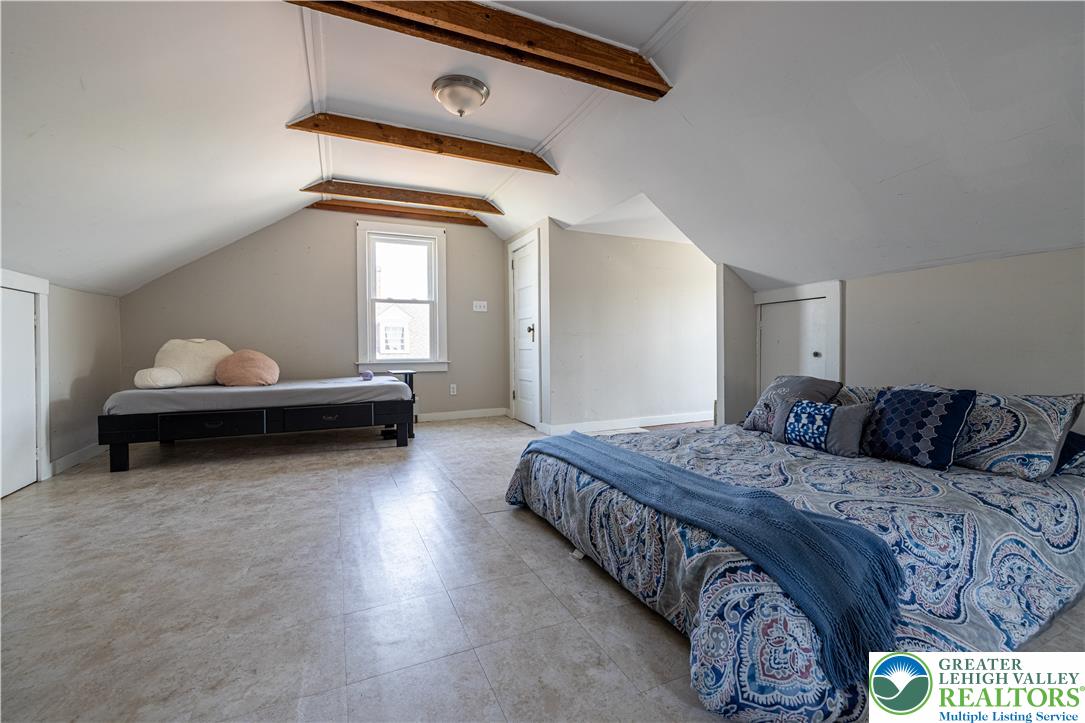 118 South 3rd Street Bangor, PA 18013 - Photo 21 of 33 This spacious bedroom features exposed beams and abundant natural light, offering a versatile living space.