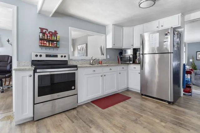 a kitchen with granite countertop a refrigerator stove and sink