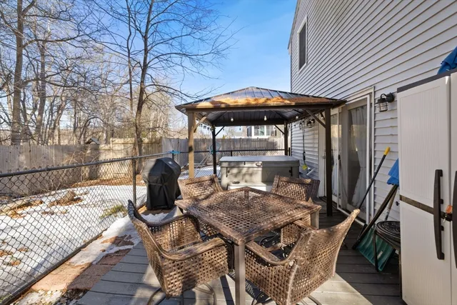 a view of a patio with a table chairs and a barbeque