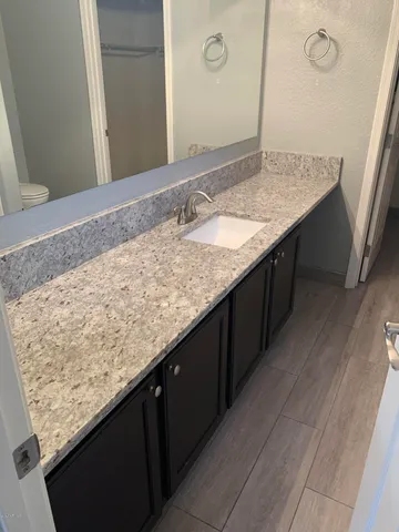 a bathroom with a granite countertop sink and a mirror