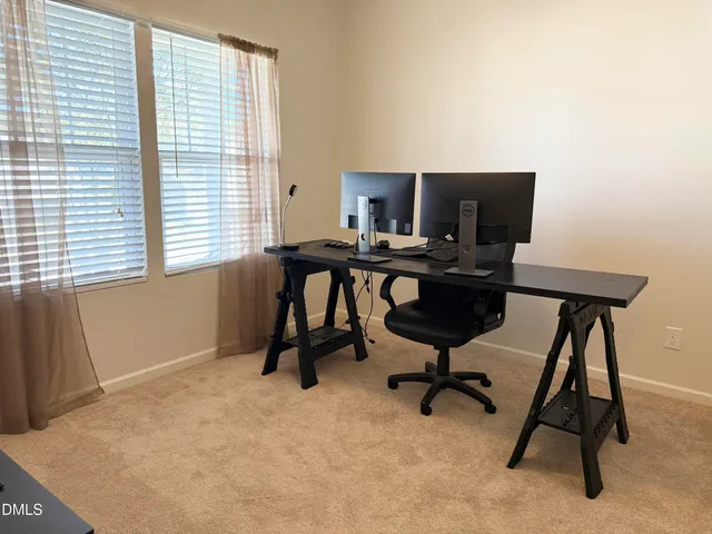 a view of a workspace with furniture and a window