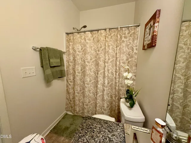 a bathroom with a shower curtain and a toilet