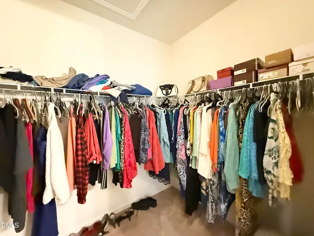 a view of walk in closet with clothes