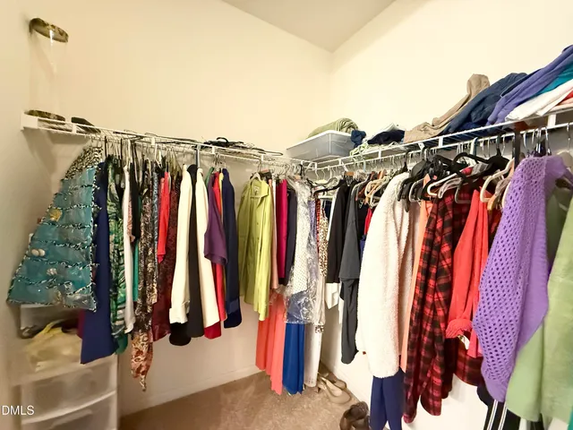 a view of walk in closet with clothes