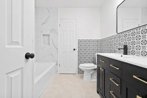 a bathroom with a sink a toilet and shower