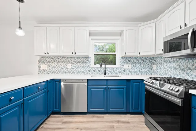 a kitchen with stainless steel appliances granite countertop a sink stove and microwave