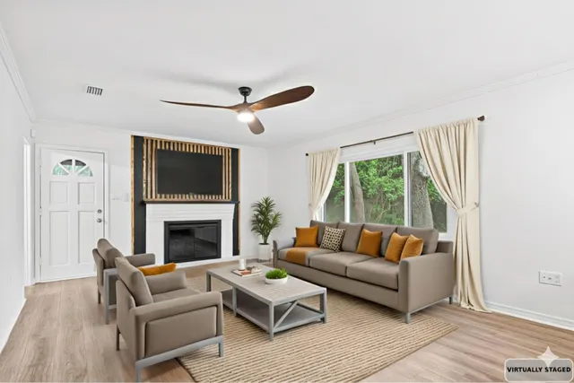 a living room with furniture a flat screen tv and a fireplace
