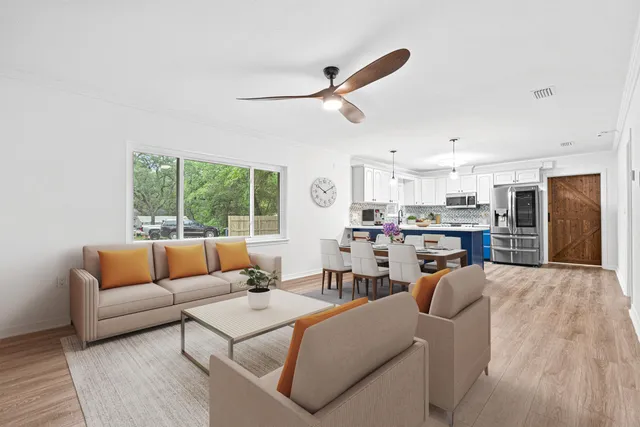 a living room with furniture kitchen view and a window