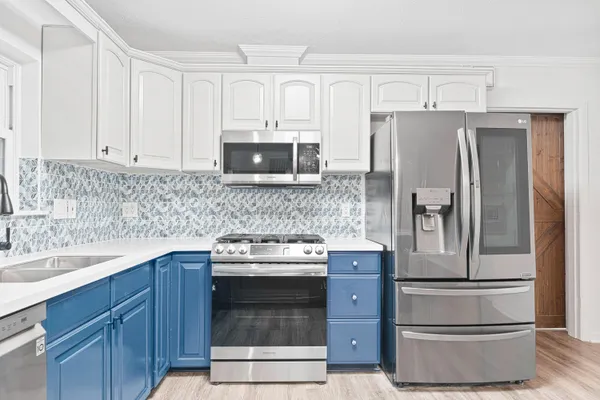 a kitchen with stainless steel appliances granite countertop a refrigerator stove and sink