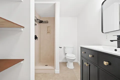 a bathroom with a sink a toilet and shower