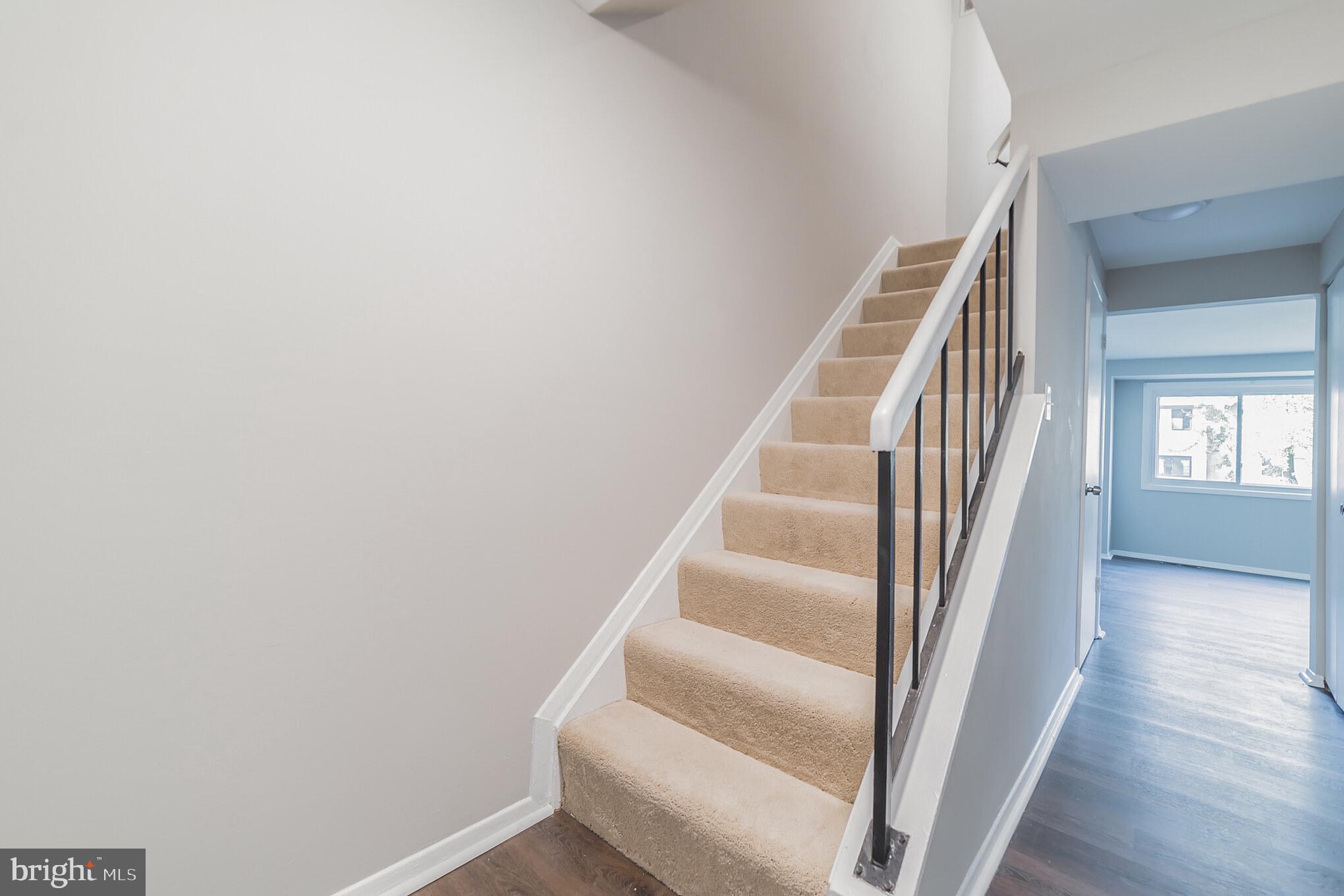 9349 Reader Lane Columbia, MD 21045 - Photo 12 of 32 a view of staircase with wooden floor and white walls