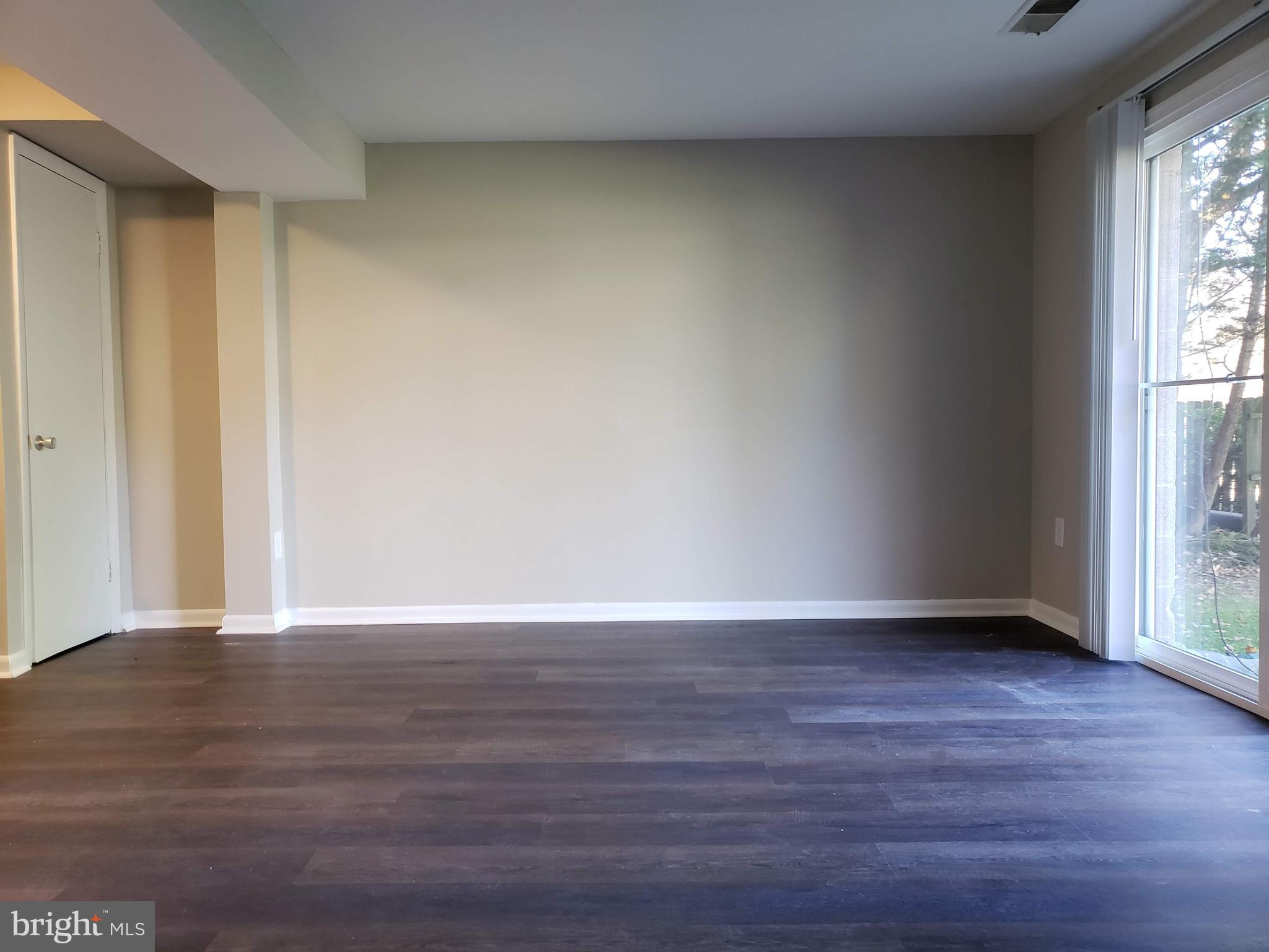 9349 Reader Lane Columbia, MD 21045 - Photo 25 of 32 a view of an empty room and wooden floor and a window