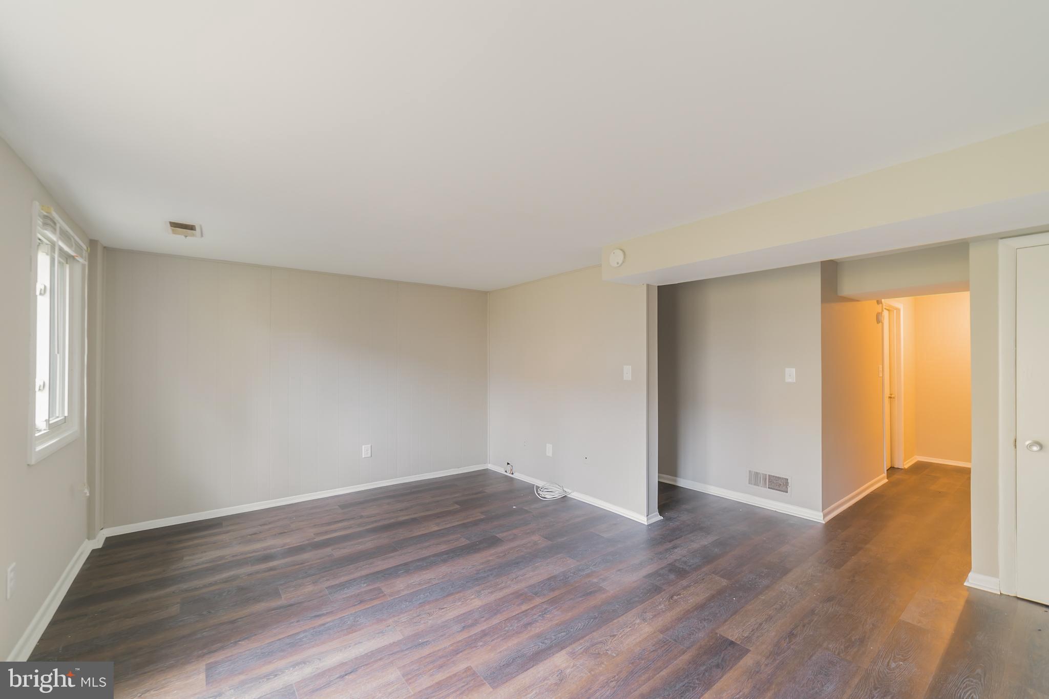 9349 Reader Lane Columbia, MD 21045 - Photo 28 of 32 a view of an empty room with wooden floor and a window