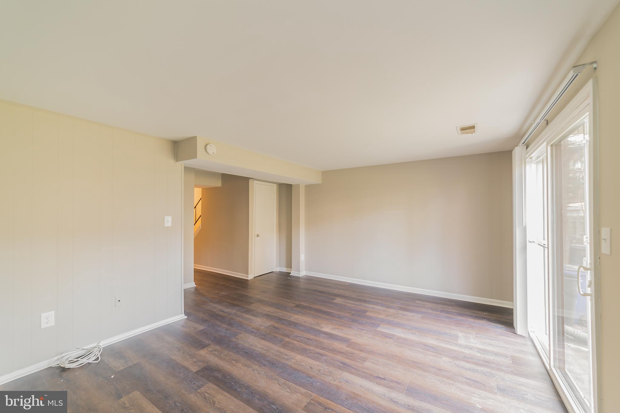 9349 Reader Lane Columbia, MD 21045 - Photo 29 of 32 a view of an empty room with wooden floor and a window