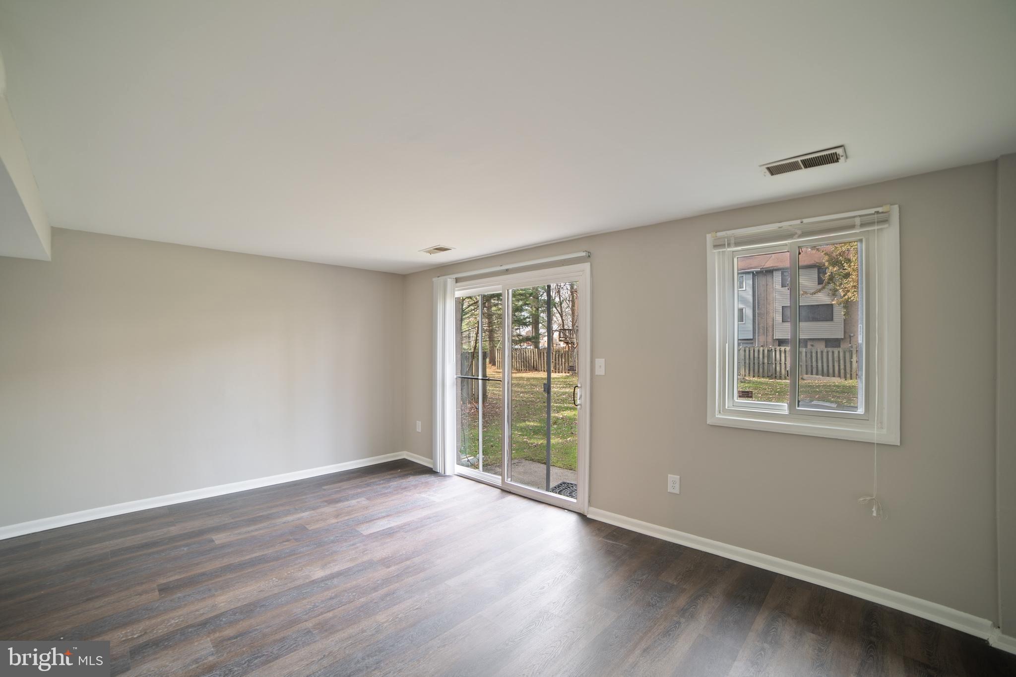 9349 Reader Lane Columbia, MD 21045 - Photo 30 of 32 a view of an empty room with wooden floor and a window