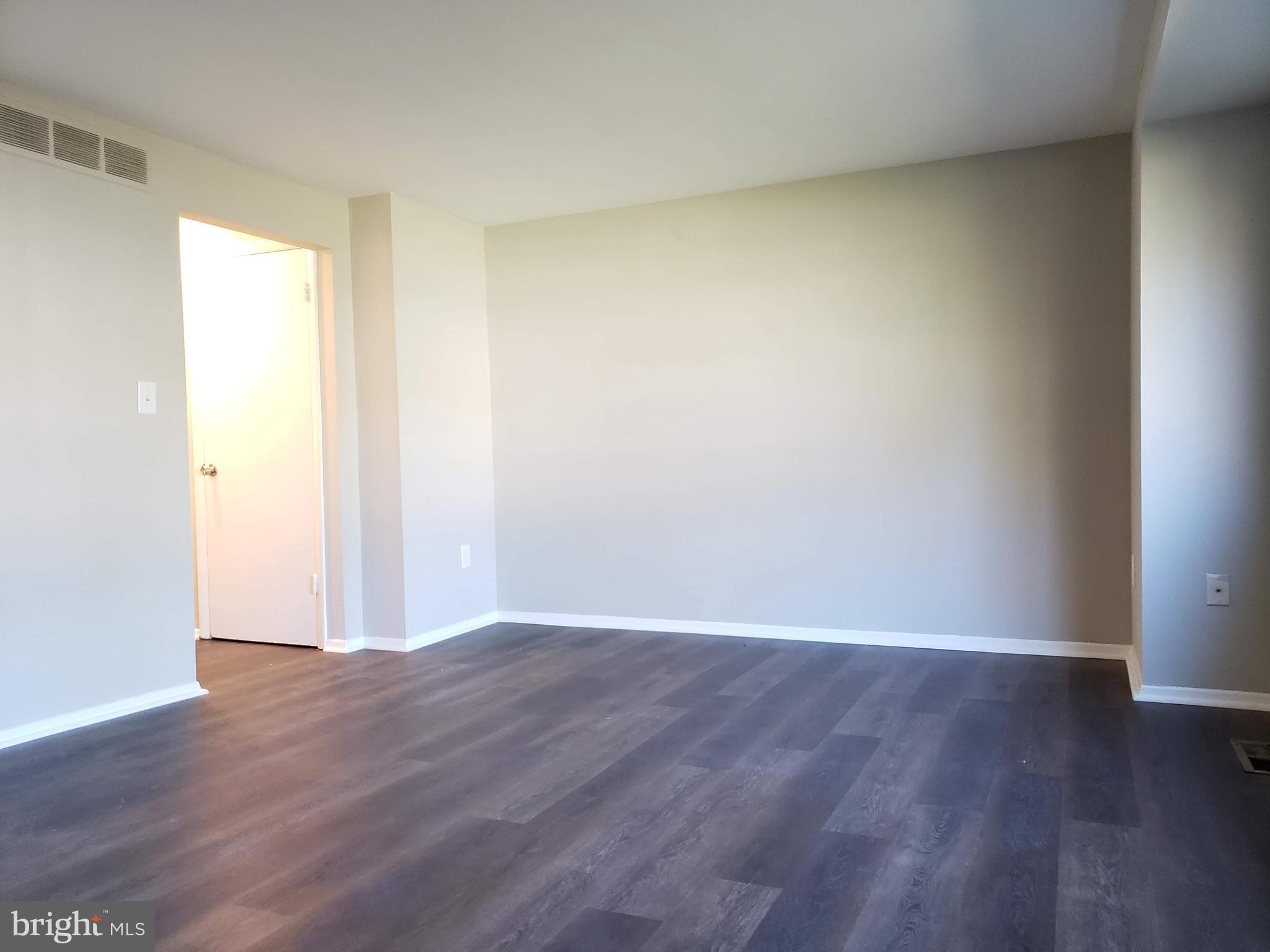 9349 Reader Lane Columbia, MD 21045 - Photo 8 of 32 a view of an empty room with wooden floor