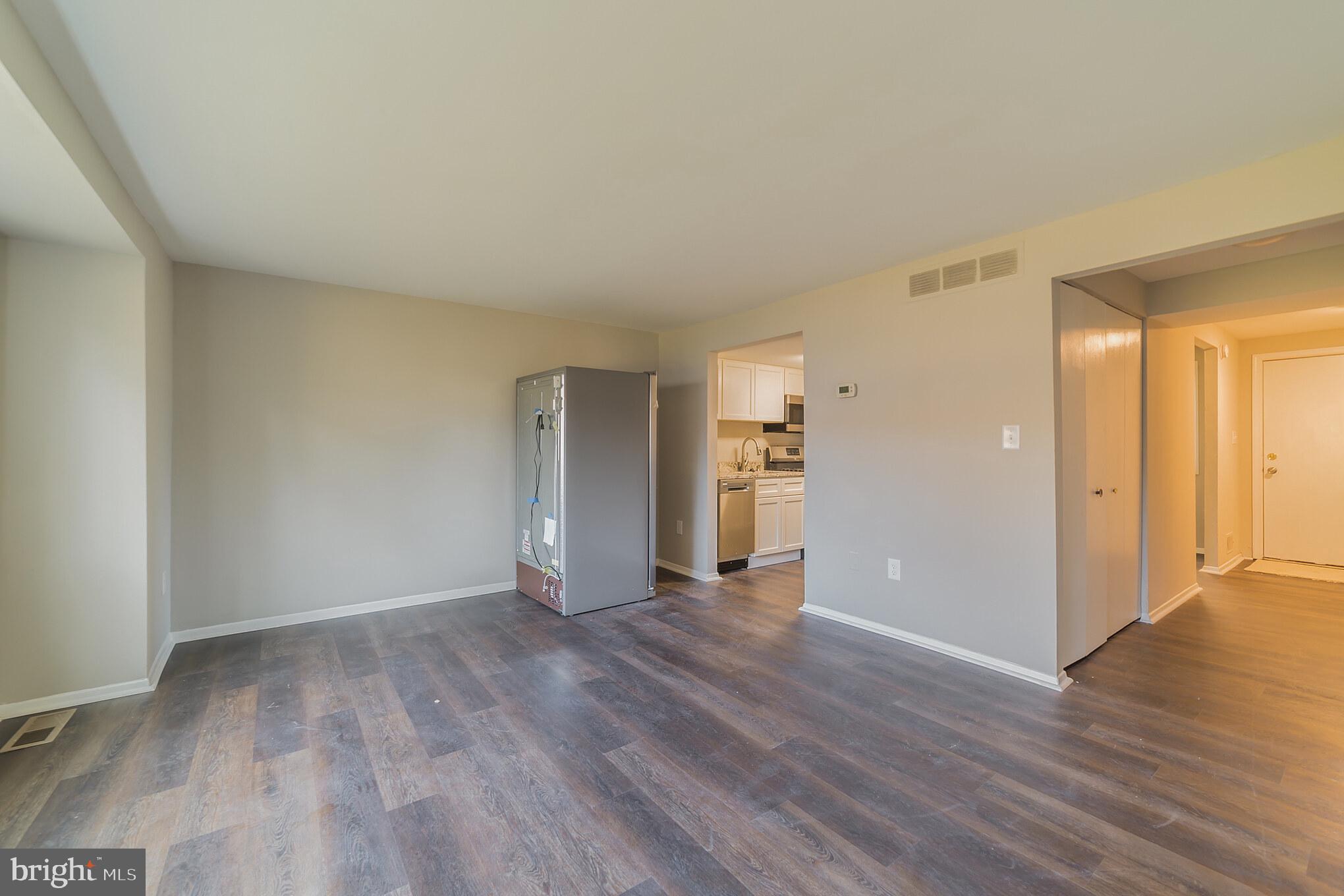 9349 Reader Lane Columbia, MD 21045 - Photo 9 of 32 an empty room with wooden floor & windows and bathroom