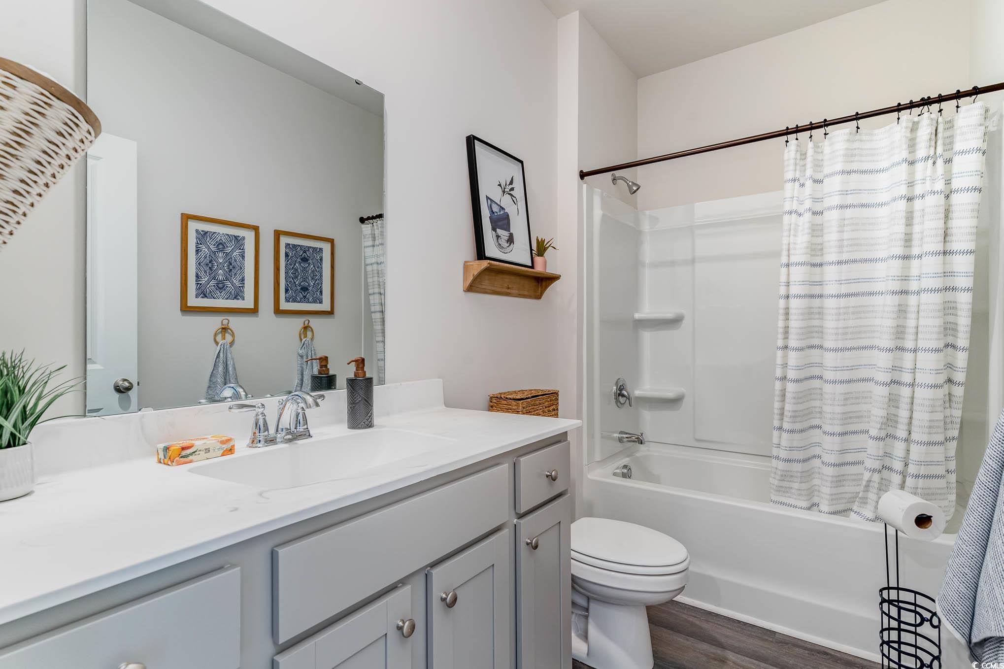 524 Duvall Street Longs, SC 29568 - Photo 5 of 20 Full bath featuring vanity, shower / bathtub combination with curtain, and wood finished floors