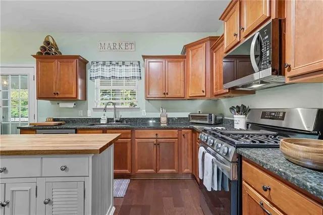 a kitchen with stainless steel appliances granite countertop a sink stove and cabinets