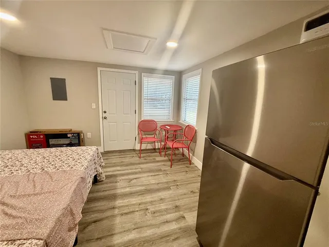 a bed room with a bed and a refrigerator
