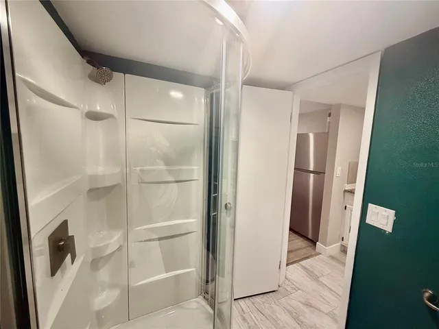 a bathroom with a glass shower door and a sink