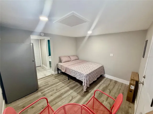 a bedroom with a bed and wooden floor