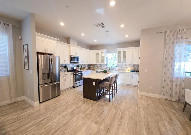 a kitchen with a refrigerator a counter top space and a center island