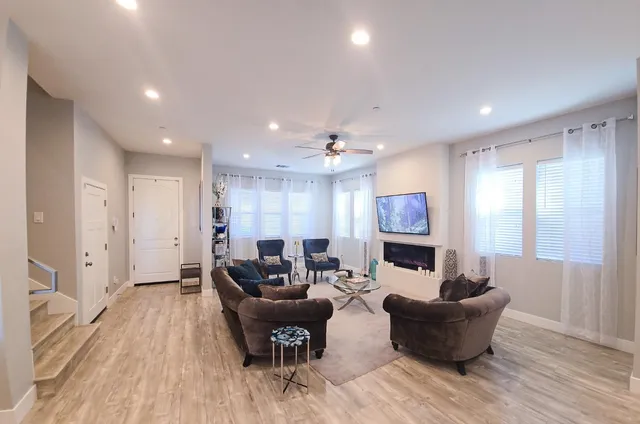 a living room with furniture and a wooden floor