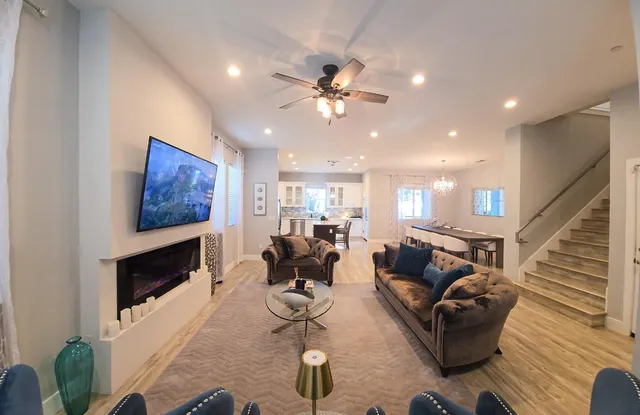 a living room with furniture a flat screen tv and a fireplace