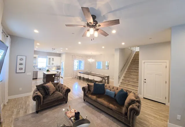 a living room with furniture and a ceiling fan