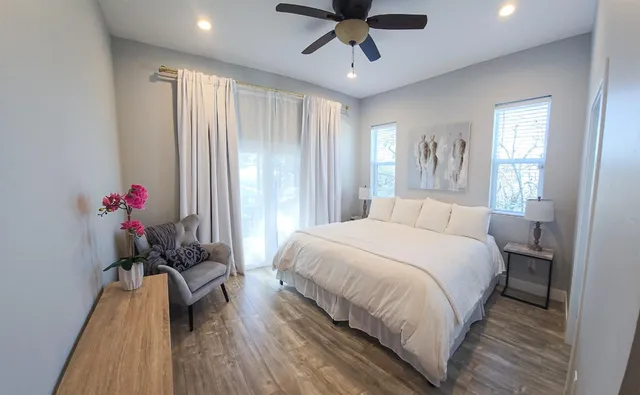 a bedroom with a bed chandelier and a window