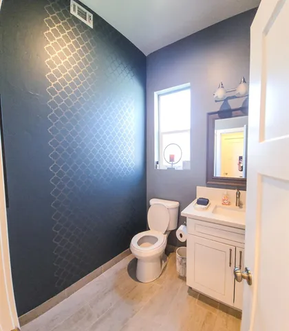 a bathroom with a toilet sink and mirror