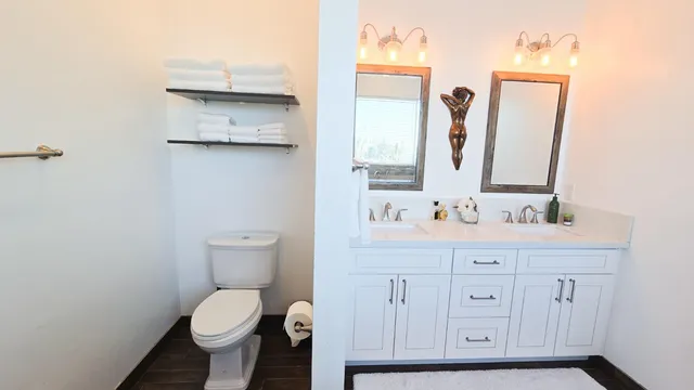 a bathroom with a granite countertop sink mirror vanity and toilet