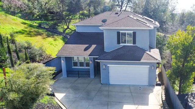 a front view of a house with a yard and trees