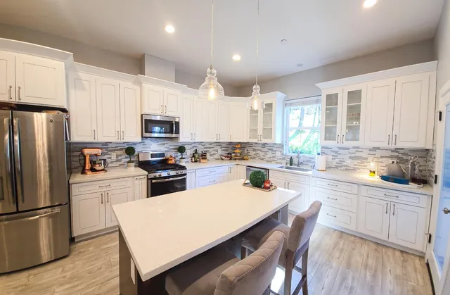 a kitchen with white cabinets and stainless steel appliances