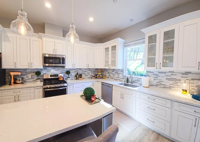 a kitchen with a sink a stove cabinets and refrigerator