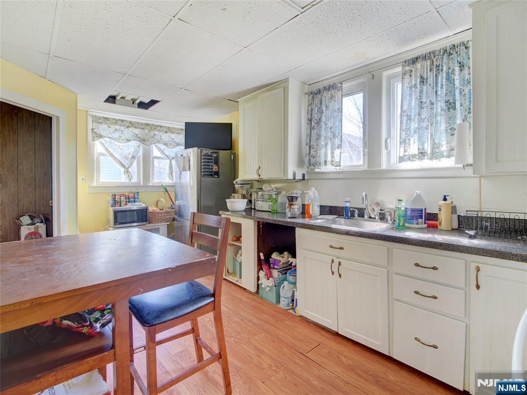 416 Jerusalem Road Scotch Plains, NJ 07076 - Photo 17 of 26 a kitchen with granite countertop a stove a sink dishwasher a dining table and chairs with wooden floor
