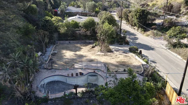 an aerial view of a house with yard and seating area