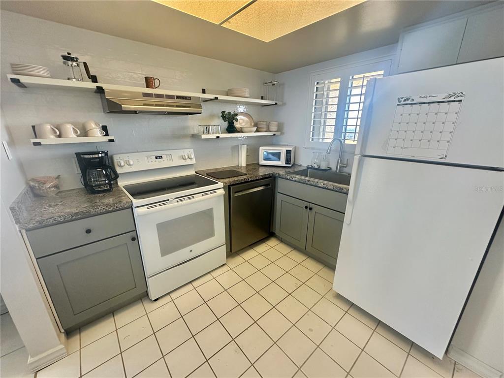 6009 Sea Ranch Drive, Unit 804 Hudson, FL 34667 - Photo 6 of 73 a kitchen with white cabinets and white appliances
